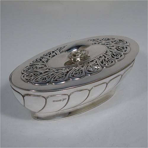 An Antique Edwardian Sterling Silver pot pourri holder, having an oval body with hand-chased fluted decoration, a lift-off lid with a cast oval handle and hand-pierced floral and scroll work, all sitting on an oval collet foot. Made by Walker and Hall of Sheffield in 1908. The dimensions of this fine hand-made antique silver pot-pourri holder are length 16 cms (6.5 inches), width height 9 cms (3.5 inches), height 7 cms (2.75 inches), and it weighs approx. 308g (10 troy ounces)   