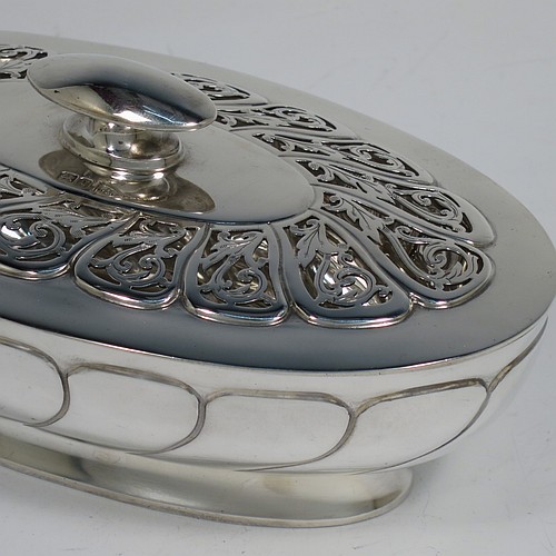 An Antique Edwardian Sterling Silver pot pourri holder, having an oval body with hand-chased fluted decoration, a lift-off lid with a cast oval handle and hand-pierced floral and scroll work, all sitting on an oval collet foot. Made by Walker and Hall of Sheffield in 1908. The dimensions of this fine hand-made antique silver pot-pourri holder are length 16 cms (6.5 inches), width height 9 cms (3.5 inches), height 7 cms (2.75 inches), and it weighs approx. 308g (10 troy ounces)