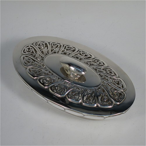 An Antique Edwardian Sterling Silver pot pourri holder, having an oval body with hand-chased fluted decoration, a lift-off lid with a cast oval handle and hand-pierced floral and scroll work, all sitting on an oval collet foot. Made by Walker and Hall of Sheffield in 1908. The dimensions of this fine hand-made antique silver pot-pourri holder are length 16 cms (6.5 inches), width height 9 cms (3.5 inches), height 7 cms (2.75 inches), and it weighs approx. 308g (10 troy ounces)