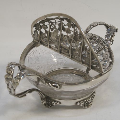 A very unusual Antique Edwardian Sterling Silver pot pourri holder, having a uniquely designed etched crystal main body with a plain rim mount, attached to which is a double hinged and pierced cover with beautiful hand-made and applied three-leaf clover decoration, together with two double-loop side-handles, and sitting on four cast floral feet. This beautiful antique silver pot-pourri holder was made by William Comyns of London in 1908. The dimensions of this fine hand-made silver pot-pourri dish are 6.5cm (2.5 inches) tall, by 16cm (6.5 inches) from handle to handle, and 10cm (4 inches) deep.