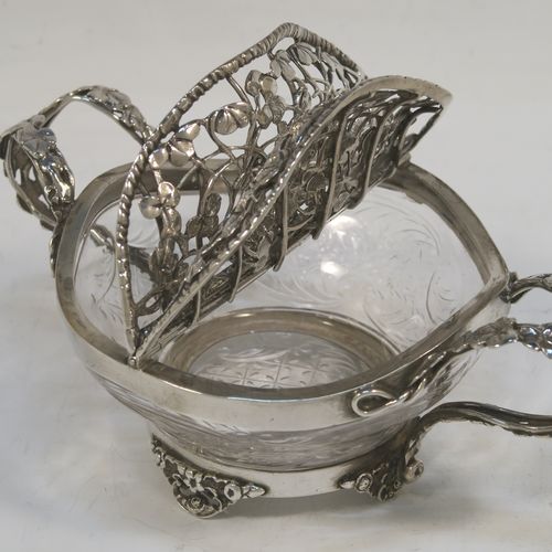 A very unusual Antique Edwardian Sterling Silver pot pourri holder, having a uniquely designed etched crystal main body with a plain rim mount, attached to which is a double hinged and pierced cover with beautiful hand-made and applied three-leaf clover decoration, together with two double-loop side-handles, and sitting on four cast floral feet. This beautiful antique silver pot-pourri holder was made by William Comyns of London in 1908. The dimensions of this fine hand-made silver pot-pourri dish are 6.5cm (2.5 inches) tall, by 16cm (6.5 inches) from handle to handle, and 10cm (4 inches) deep.