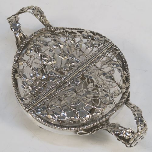 A very unusual Antique Edwardian Sterling Silver pot pourri holder, having a uniquely designed etched crystal main body with a plain rim mount, attached to which is a double hinged and pierced cover with beautiful hand-made and applied three-leaf clover decoration, together with two double-loop side-handles, and sitting on four cast floral feet. This beautiful antique silver pot-pourri holder was made by William Comyns of London in 1908. The dimensions of this fine hand-made silver pot-pourri dish are 6.5cm (2.5 inches) tall, by 16cm (6.5 inches) from handle to handle, and 10cm (4 inches) deep.