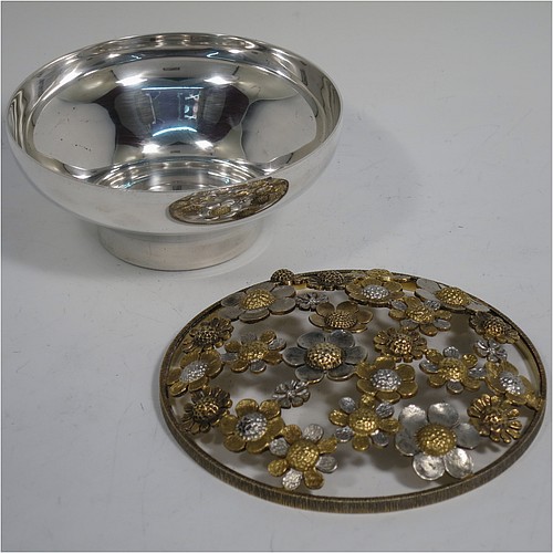A very pretty Sterling Silver pot pourri holder, having a plain round bellied lower body, and a pull-off pierced grill made up of joined cast flower heads in differing sizes, some of which are gold-gilt, and all sitting on a flat base. Made by Richard Cooke of London in 1983. The dimensions of this fine hand-made silver pot-pourri holder are diameter 11 cms (4.25 inches), height 5.5 cms (2.25 inches), and it weighs approx. 235g (7.6 troy ounces).