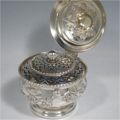 An Antique Edwardian Sterling Silver pot pourri holder, having a round bellied hand-body body with bird and floral decoration, a hinged lid with cast floral finial, and an internal pull-off pierced grill with ball finial, all sitting on a pedestal foot. Made by Nathan & Hayes of Chester in 1909. The dimensions of this fine hand-made antique silver pot-pourri holder are diameter 9 cms (3.5 inches), height 11 cms (4.3 inches), and it weighs approx. 157g (6 troy ounces).