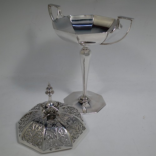 A very handsome and large Antique Edwardian Sterling Silver pot pourri holder in an Art Nouveau style, having an unusual trophy shaped body with two-side-handles, a lift off hand-pierced and panelled lid with cast urn-shaped finial, and all sitting on an octagonal pedestal foot. Made by Goldsmiths and Silversmiths of London in 1907. The dimensions of this fine hand-made antique silver pot-pourri holder are height 28 cms (11 inches), spread across arms 18.5 cms (7.25 inches), and it weighs approx. 482g (15.5 troy ounces)