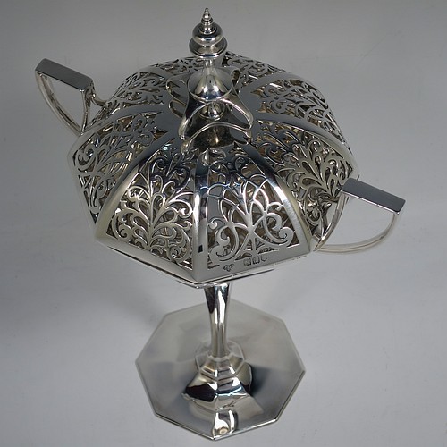 A very handsome and large Antique Edwardian Sterling Silver pot pourri holder in an Art Nouveau style, having an unusual trophy shaped body with two-side-handles, a lift off hand-pierced and panelled lid with cast urn-shaped finial, and all sitting on an octagonal pedestal foot. Made by Goldsmiths and Silversmiths of London in 1907. The dimensions of this fine hand-made antique silver pot-pourri holder are height 28 cms (11 inches), spread across arms 18.5 cms (7.25 inches), and it weighs approx. 482g (15.5 troy ounces)