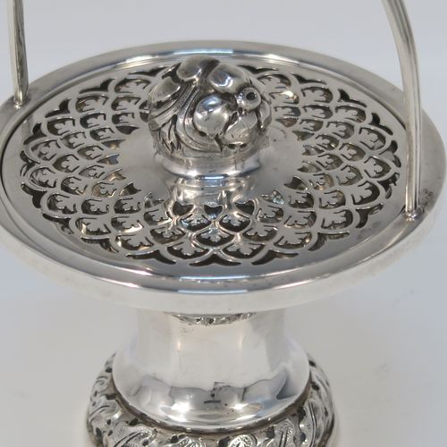 A beautiful Antique Edwardian Sterling Silver pot pourri holder, having a round panelled body and pedestal foot, a reeded loop carrying handle, and a pull-off lid with hand-pierced decoration surrounding a round cast floral finial. This pretty pot-pourri covered dish was made by Sharman D. Neill of Chester in 1910. The dimensions of this fine hand-made antique silver pot-pourri holder are height (inc. handle) 14 cms (5.5 inches), diameter of main body 8.5 cms (3.3 inches), and it weighs approx. 109g (3.5 troy ounces).