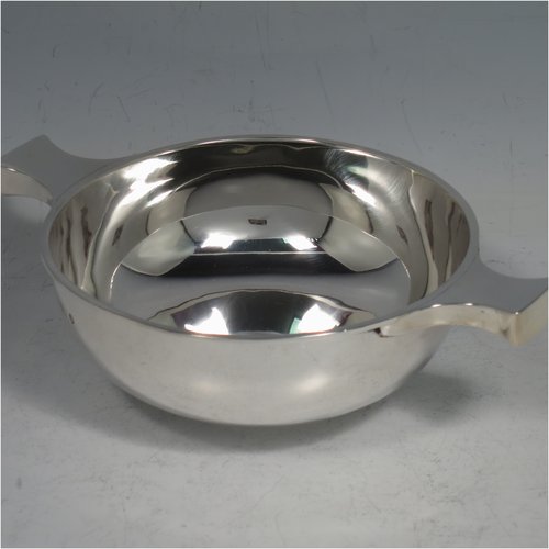 An Antique Victorian Sterling silver Scottish quaich, having a very plain round body, with two side handles, sitting on a collet foot. Made by Brook & Son of Edinburgh in 1889. The dimensions of this fine hand-made antique silver quaich are diameter of body 11 cms (4.25 inches), height 4 cms (1.5 inches), and it weighs approx. 145g (4.7 troy ounces).