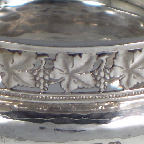 A Sterling silver Arts & Crafts style quaich, having a round baluster body with hand-hammered decoration, a hand-pierced grape-vine border, with two cast side-handles showing a scene with fox and tree, and all sitting on a flat base. Made by A. E. Jones of Birmingham in 1928. The dimensions of this fine hand-made silver Arts and Crafts quaich are diameter of body 12 cms (4.75 inches), height 4 cms (1.5 inches), and it weighs approx. 151g (4.9 troy ounces).