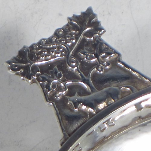 A Sterling silver Arts & Crafts style quaich, having a round baluster body with hand-hammered decoration, a hand-pierced grape-vine border, with two cast side-handles showing a scene with fox and tree, and all sitting on a flat base. Made by A. E. Jones of Birmingham in 1928. The dimensions of this fine hand-made silver Arts and Crafts quaich are diameter of body 12 cms (4.75 inches), height 4 cms (1.5 inches), and it weighs approx. 151g (4.9 troy ounces).