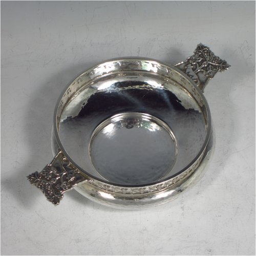 A Sterling silver Arts & Crafts style quaich, having a round baluster body with hand-hammered decoration, a hand-pierced grape-vine border, with two cast side-handles showing a scene with fox and tree, and all sitting on a flat base. Made by A. E. Jones of Birmingham in 1928. The dimensions of this fine hand-made silver Arts and Crafts quaich are diameter of body 12 cms (4.75 inches), height 4 cms (1.5 inches), and it weighs approx. 151g (4.9 troy ounces).