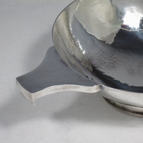 A Sterling Silver large Scottish quaich (being a replica of a Charles I example dated 1626), having a very plain round body with hand-hammered finish, with two side handles, and sitting on a collet foot. Made by Robert Sawers of Edinburgh in 1926. The dimensions of this fine hand-made silver quaich are diameter of body 15 cms (6 inches), height 5 cms (2 inches), and it weighs approx. 310g (10 troy ounces).
