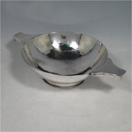 A Sterling Silver large Scottish quaich (being a replica of a Charles I example dated 1626), having a very plain round body with hand-hammered finish, with two side handles, and sitting on a collet foot. Made by Robert Sawers of Edinburgh in 1926. The dimensions of this fine hand-made silver quaich are diameter of body 15 cms (6 inches), height 5 cms (2 inches), and it weighs approx. 310g (10 troy ounces).