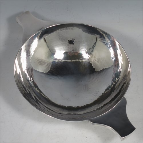 A Sterling Silver large Scottish quaich (being a replica of a Charles I example dated 1626), having a very plain round body with hand-hammered finish, with two side handles, and sitting on a collet foot. Made by Robert Sawers of Edinburgh in 1926. The dimensions of this fine hand-made silver quaich are diameter of body 15 cms (6 inches), height 5 cms (2 inches), and it weighs approx. 310g (10 troy ounces).