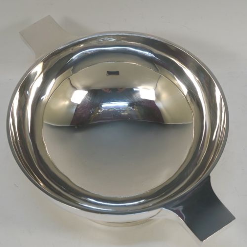 A handsome and very large Sterling Silver quaich, having a very plain round body, with two side handles, and sitting on a pedestal foot. This beautiful silver quaich bowl was made by Walker and Hall of Sheffield in 1937. The dimensions of this fine hand-made silver quaich bowl are diameter of body 20 cms (8 inches), height 10 cms (4 inches), and it weighs approx. 569g (18 troy ounces).