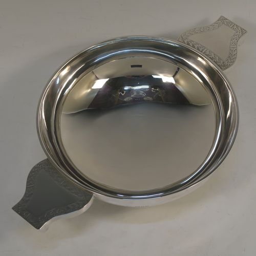 A large and handsome Sterling Silver quaich, having a very plain round body, with two side handles having hand-engraved geometrical engraving, and sitting on a collet foot. This elegant silver quaich was made by Robert Stebbings of London in 1927. The dimensions of this fine hand-made sterling silver quaich are diameter of body 18 cms (7 inches), height 6.5 cms (2.5 inches), and it weighs approx. 423g (13.6 troy ounces).
