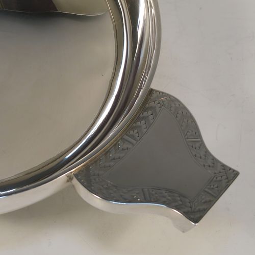 A large and handsome Sterling Silver quaich, having a very plain round body, with two side handles having hand-engraved geometrical engraving, and sitting on a collet foot. This elegant silver quaich was made by Robert Stebbings of London in 1927. The dimensions of this fine hand-made sterling silver quaich are diameter of body 18 cms (7 inches), height 6.5 cms (2.5 inches), and it weighs approx. 423g (13.6 troy ounces).