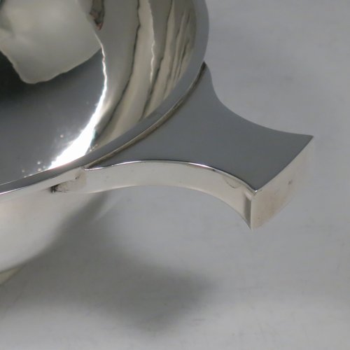 A Sterling Silver Scottish quaich, having a very plain round body, with two side handles, sitting on a collet foot. Made by Hamilton & Inches of Edinburgh in 1977. The dimensions of this fine hand-made silver quaich are diameter of body 13 cms (5 inches), height 5 cms (2 inches), and it weighs approx. 217g (7 troy ounces).