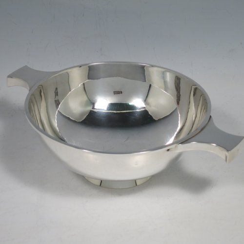 A Sterling Silver Scottish quaich, having a very plain round body, with two side handles, sitting on a collet foot. Made by Hamilton & Inches of Edinburgh in 1977. The dimensions of this fine hand-made silver quaich are diameter of body 13 cms (5 inches), height 5 cms (2 inches), and it weighs approx. 217g (7 troy ounces).