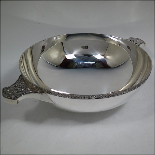 A very large and handsome Sterling Silver Celtic quaich, having a very plain round body, with two cast side handles in a Celtic style, a matching applied border, and sitting on a collet foot. Made by Wakely & Wheeler of London in 1988. The dimensions of this fine hand-made silver Celtic quaich are diameter of body 25 cms (10 inches), height 9 cms (3.5 inches), and it weighs approx. 925g (30 troy ounces).    