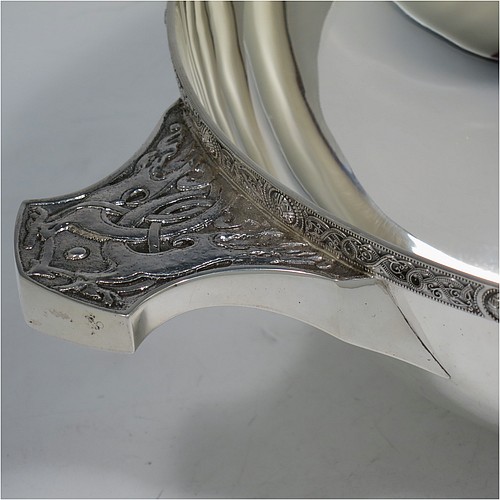 A very large and handsome Sterling Silver Celtic quaich, having a very plain round body, with two cast side handles in a Celtic style, a matching applied border, and sitting on a collet foot. Made by Wakely & Wheeler of London in 1988. The dimensions of this fine hand-made silver Celtic quaich are diameter of body 25 cms (10 inches), height 9 cms (3.5 inches), and it weighs approx. 925g (30 troy ounces).