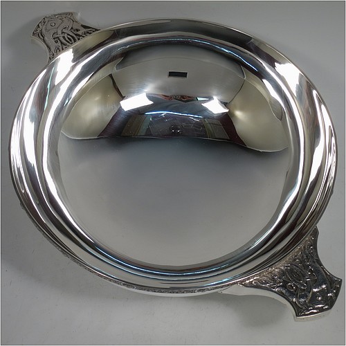 A very large and handsome Sterling Silver Celtic quaich, having a very plain round body, with two cast side handles in a Celtic style, a matching applied border, and sitting on a collet foot. Made by Wakely & Wheeler of London in 1988. The dimensions of this fine hand-made silver Celtic quaich are diameter of body 25 cms (10 inches), height 9 cms (3.5 inches), and it weighs approx. 925g (30 troy ounces).