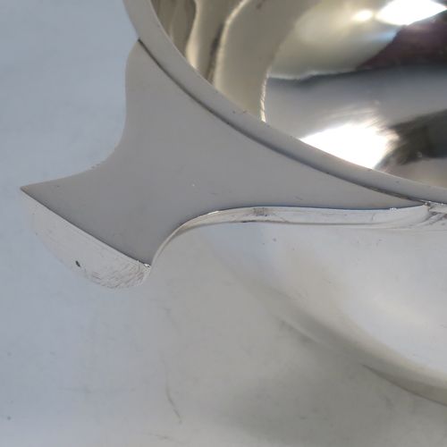 A very handsome Sterling Silver Scottish quaich, having a very plain round body, with two side handles, and sitting on a collet foot. Made by Mackay and Chisholm of Edinburgh in 1929. The dimensions of this fine hand-made silver quaich are diameter of body 11.5 cms (4.5 inches), height 5 cms (2 inches), and it weighs approx. 172g (5.5 troy ounces).