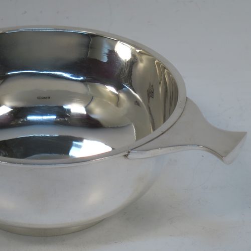 A very handsome Sterling Silver Scottish quaich, having a very plain round body, with two side handles, and sitting on a collet foot. Made by Mackay and Chisholm of Edinburgh in 1929. The dimensions of this fine hand-made silver quaich are diameter of body 11.5 cms (4.5 inches), height 5 cms (2 inches), and it weighs approx. 172g (5.5 troy ounces).