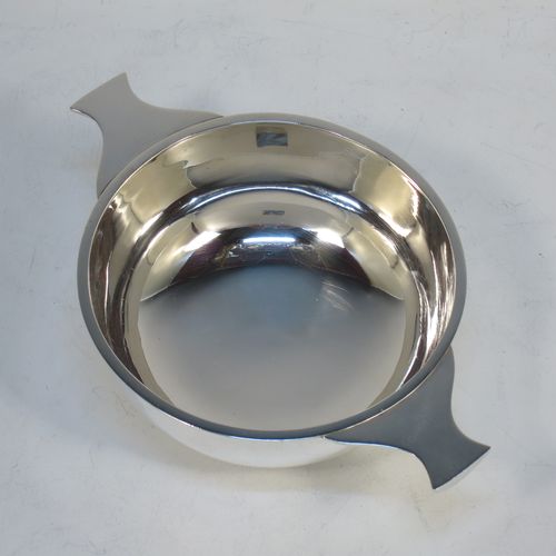 A very handsome Sterling Silver Scottish quaich, having a very plain round body, with two side handles, and sitting on a collet foot. Made by Mackay and Chisholm of Edinburgh in 1929. The dimensions of this fine hand-made silver quaich are diameter of body 11.5 cms (4.5 inches), height 5 cms (2 inches), and it weighs approx. 172g (5.5 troy ounces).