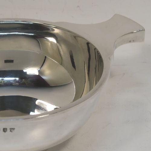 A very handsome Sterling Silver Scottish quaich, having a very plain round body, with two side handles, and sitting on a collet foot. This elegant silver quaich was made by Mackay and Chisholm of Edinburgh in 1927. The dimensions of this fine hand-made silver quaich are diameter of body 11.5 cms (4.5 inches), height 5 cms (2 inches), and it weighs approx. 192g (6.2 troy ounces).
