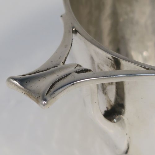 An unusual Antique Edwardian Sterling silver Arts & Crafts style Quaich, having a round bellied body with hand-hammered decoration, with two pierced tendril style side-handles, and all sitting on a flat base. This elegant silver quaich style bowl was made by D. and J. Welby of London in 1903. The dimensions of this fine hand-made silver Arts and Crafts style quaich are diameter of body 10.5 cms (4.25 inches), height 6 cms (2.3 inches), and it weighs approx. 246g (7.9 troy ounces).