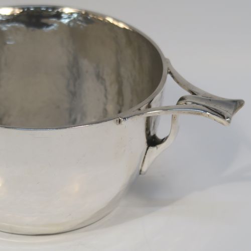 An unusual Antique Edwardian Sterling silver Arts & Crafts style Quaich, having a round bellied body with hand-hammered decoration, with two pierced tendril style side-handles, and all sitting on a flat base. This elegant silver quaich style bowl was made by D. and J. Welby of London in 1903. The dimensions of this fine hand-made silver Arts and Crafts style quaich are diameter of body 10.5 cms (4.25 inches), height 6 cms (2.3 inches), and it weighs approx. 246g (7.9 troy ounces).