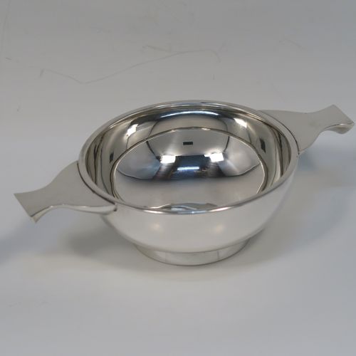 A handsome Scottish Sterling Silver Quaich, having a very plain round body, with two side handles, and sitting on a collet foot. This elegant silver Quaich was made by James Ness and Son of Edinburgh in 1968. The dimensions of this fine hand-made silver Scottish Quaich are diameter of body 9 cms (3.5 inches), height 4 cms (1.5 inches), and it weighs approx. 120g (3.9 troy ounces).   