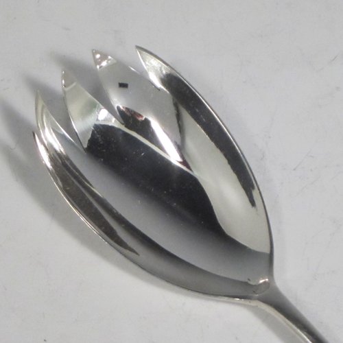 Sterling silver pair of salad servers, having very plain oval bowls, featuring long handles with hand-chased shaped gadroon an floral terminals. Made by Goldsmiths and Silversmiths of Sheffield in 1920. The length of these fine hand-made silver salad servers are 28 cms (11 inches), and the total weight is approx. 196g (6.3 troy ounces).