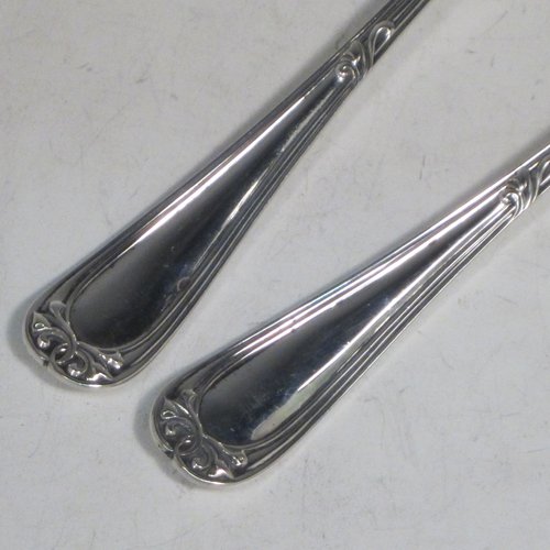 Antique Edwardian sterling silver pair of salad servers, having very plain oval bowls, featuring reeded handles with hand-chased floral terminals. Made by Roberts and Belk of Sheffield in 1907. The length of these fine hand-made silver salad servers are 22 cms (8.75 inches), and the total weight is approx. 198g (6.4 troy ounces).