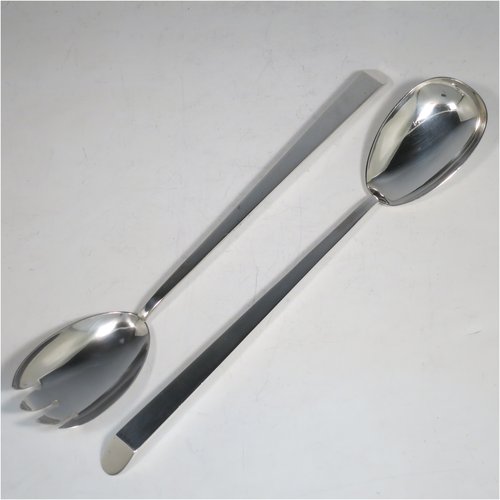 An Antique Edwardian Sterling Silver pair of Arts and Crafts salad servers, having very plain bodies with oval bowls, featuring tapered handles with chamfered ends. Made by Elkington & Co., of Birmingham in 1907. The length of these fine hand-made antique silver salad servers are 27 cms (10.75 inches), and the total weight is approx. 132g (4.3 troy ounces).