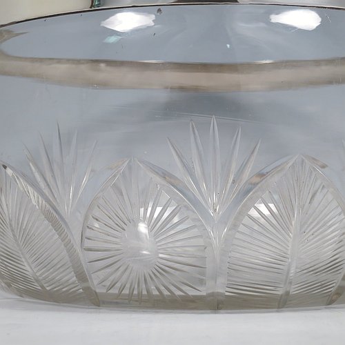 A Sterling Silver and hand-cut crystal salad bowl, having a round body with a plain applied silver rim, sitting on a hand-cut crystal base with floral and leaf engraving, and a star-cut flat base. Made by BS & Co., of London in 1921. The dimensions of this fine hand-made silver and crystal salad bowl are diameter 21 cms (8.25 inches), and height 11 cms (4.25 inches).