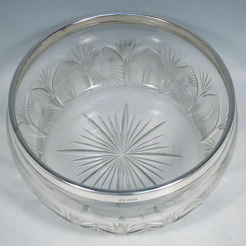 A Sterling Silver and hand-cut crystal salad bowl, having a round body with a plain applied silver rim, sitting on a hand-cut crystal base with floral and leaf engraving, and a star-cut flat base. Made by BS & Co., of London in 1921. The dimensions of this fine hand-made silver and crystal salad bowl are diameter 21 cms (8.25 inches), and height 11 cms (4.25 inches).