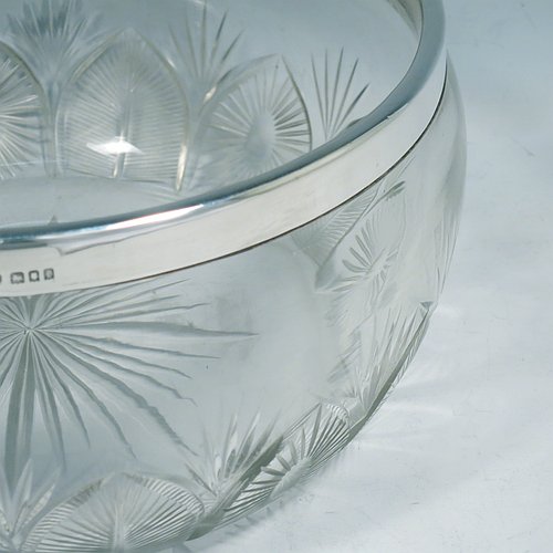 A Sterling Silver and hand-cut crystal salad bowl, having a round body with a plain applied silver rim, sitting on a hand-cut crystal base with floral and leaf engraving, and a star-cut flat base. Made by BS & Co., of London in 1921. The dimensions of this fine hand-made silver and crystal salad bowl are diameter 21 cms (8.25 inches), and height 11 cms (4.25 inches).