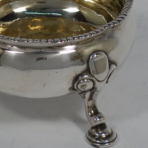 A large and handsome pair of Antique Georgian Sterling Silver salt cellars, having plain round bodies, with gold-gilt interiors, applied shaped gadroon borders, and all sitting on three cast hoof feet with foliate shoulders. Made by Peter Taylor of London in 1750. The dimensions of these fine hand-made antique silver salt cellars are diameter 8 cms (3 inches), height 5 cms (2 inches), and they weigh a total of approx. 224g (7.2 troy ounces). Please note that these items are crested.