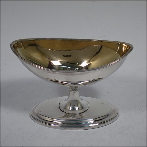 A rare and very handsome Antique Georgian Sterling Silver pair of Irish salt cellars, in a boat-shaped neoclassical style, having plain oval bodies, with gold-gilt interiors and blue-glass liners, with applied reeded borders, all sitting on pedestal feet. Made by John Stoyte of Dublin in 1798. The dimensions of these fine hand-made antique silver Irish salt cellars are length 10 cms (4 inches), width 5.5 cms (2.25 inches), height 6.5 cms (2.5 inches), and they weigh a total of approx. 142g (4.6 troy ounces).
