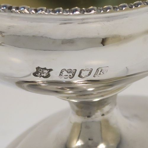 A very handsome Antique Edwardian Sterling Silver pair of salt cellars, in a boat-shaped style, having plain oval bodies, with gold-gilt interiors, applied gadroon borders, and all sitting on oval pedestal feet. These elegant antique silver salt dishes were made by D. and J. Welby of London in 1905. The dimensions of these fine hand-made antique silver salt cellars are length 10 cms (4 inches), width 6.5 cms (2.5 inches), height 6.5 cms (2.5 inches), and they weigh a total of approx. 162g (5.2 troy ounces).