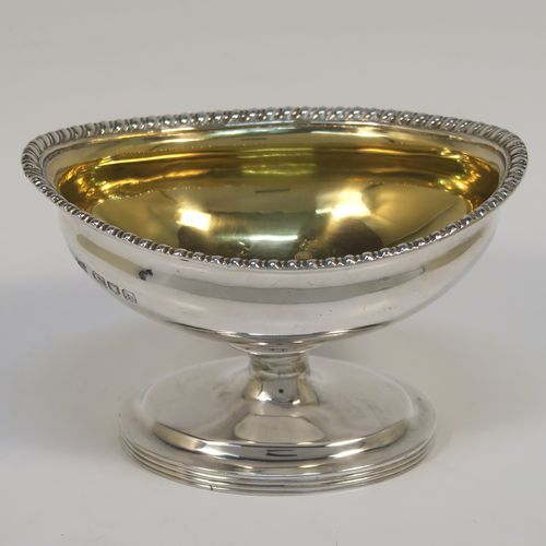 A very handsome Antique Edwardian Sterling Silver pair of salt cellars, in a boat-shaped style, having plain oval bodies, with gold-gilt interiors, applied gadroon borders, and all sitting on oval pedestal feet. These elegant antique silver salt dishes were made by D. and J. Welby of London in 1905. The dimensions of these fine hand-made antique silver salt cellars are length 10 cms (4 inches), width 6.5 cms (2.5 inches), height 6.5 cms (2.5 inches), and they weigh a total of approx. 162g (5.2 troy ounces).