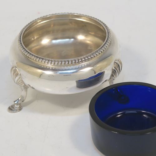 A large and pretty pair of Antique Victorian Sterling Silver cauldron salt cellars, having round bellied bodies with applied bead-edged borders, blue glass liners, and sitting on three cast hoof feet with shell shoulders. These beautiful antique silver salt cellars were made by Arthur Sibley of London in 1862. The dimensions of these fine hand-made antique silver salt cellars are diameter 7 cms (2.75 inches), height 4 cms (1.5 inches), and they weigh a total of approx. 136g (4.4 troy ounces).