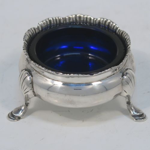 A very handsome pair of Antique Sterling Silver salt cellars, having plain round bellied bodies, with blue-glass liners, applied shaped gadroon borders, and all sitting on three cast hoof feet with reeded shoulders. These elegant silver salt cellars were made by Stokes and Ireland of Chester in 1919. The dimensions of these fine hand-made antique silver salt cellars are diameter 6 cms (2.3 inches), height 3.5 cms (1.3 inches), and they weigh a total of approx. 99g (3.2 troy ounces).