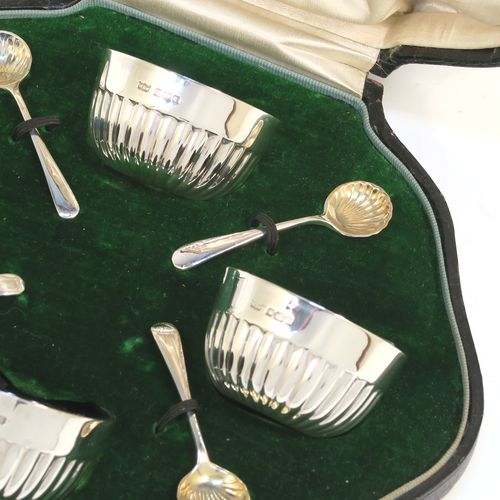A very pretty set of four Antique Sterling Silver salt cellars, having round bellied bodies with hand-chased half-fluted decoration, with blue glass liners, and sitting on flat bases, together with four original salt spoons, all in their cream satin and green velvet-line presentation box. These beautiful antique silver salt cellars and condiment spoons were made by Mappin and Webb of Sheffield in 1917. The dimensions of these fine hand-made antique silver salt cellars are diameter 5.5 cms (2.2 inches), height 3 cms (1.25 inches), and they weigh a total of approx. 143g (4.6 troy ounces).