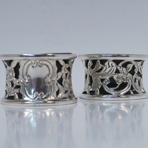 A very unusual and pretty pair of Irish Antique Victorian Sterling Silver salt cellars, in the shape of miniature potato or dish rings, having round bodies with hand-chased and hand-pierced concave shaped sides, together with hand-blown blue glass liners. These interesting antique silver salt cellars in a Potato dish ring style were made by Samuel Le Bas of Dublin in 1895. The dimensions of these fine hand-made silver salt cellars are diameter 5 cms (2 inches), height 3 cms (1.25 inches), and they weigh a total of approx. 65g (2 troy ounces).