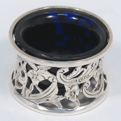 A very unusual and pretty pair of Irish Antique Victorian Sterling Silver salt cellars, in the shape of miniature potato or dish rings, having round bodies with hand-chased and hand-pierced concave shaped sides, together with hand-blown blue glass liners. These interesting antique silver salt cellars in a Potato dish ring style were made by Samuel Le Bas of Dublin in 1895. The dimensions of these fine hand-made silver salt cellars are diameter 5 cms (2 inches), height 3 cms (1.25 inches), and they weigh a total of approx. 65g (2 troy ounces).