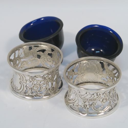 A very unusual and pretty pair of Irish Antique Victorian Sterling Silver salt cellars, in the shape of miniature potato or dish rings, having round bodies with hand-chased and hand-pierced concave shaped sides, together with hand-blown blue glass liners. These interesting antique silver salt cellars in a Potato dish ring style were made by Samuel Le Bas of Dublin in 1895. The dimensions of these fine hand-made silver salt cellars are diameter 5 cms (2 inches), height 3 cms (1.25 inches), and they weigh a total of approx. 65g (2 troy ounces).