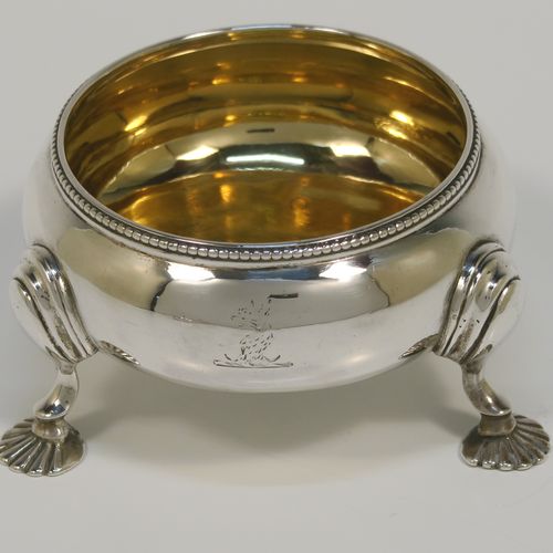 A large and handsome pair of Antique Victorian Sterling Silver salt cellars, having plain round bellied bodies, with gold-gilt interiors, applied shaped bead-edged top borders, and all sitting on three cast shell feet with reeded shoulders. These elegant silver salt cellars were made by Alfred Ivory of London in 1861. The dimensions of these fine hand-made antique silver salt cellars are diameter 7.5 cms (3 inches), height 4 cms (1.5 inches), and they weigh a total of approx. 155g (5 troy ounces). Please note that these items are crested.